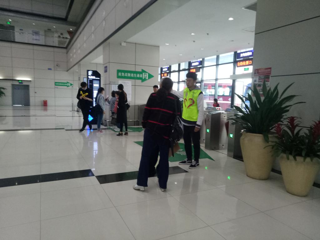 图2 检票处为老爷爷指路的志愿者 图2 检票处为老爷爷指路的志愿者