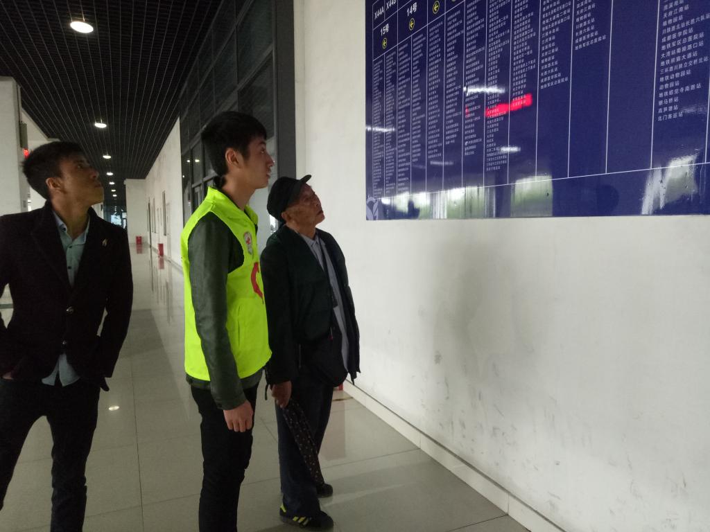 图4 帮老爷爷查看公交车运行图的志愿者 图4 帮老爷爷查看公交车运行图的志愿者